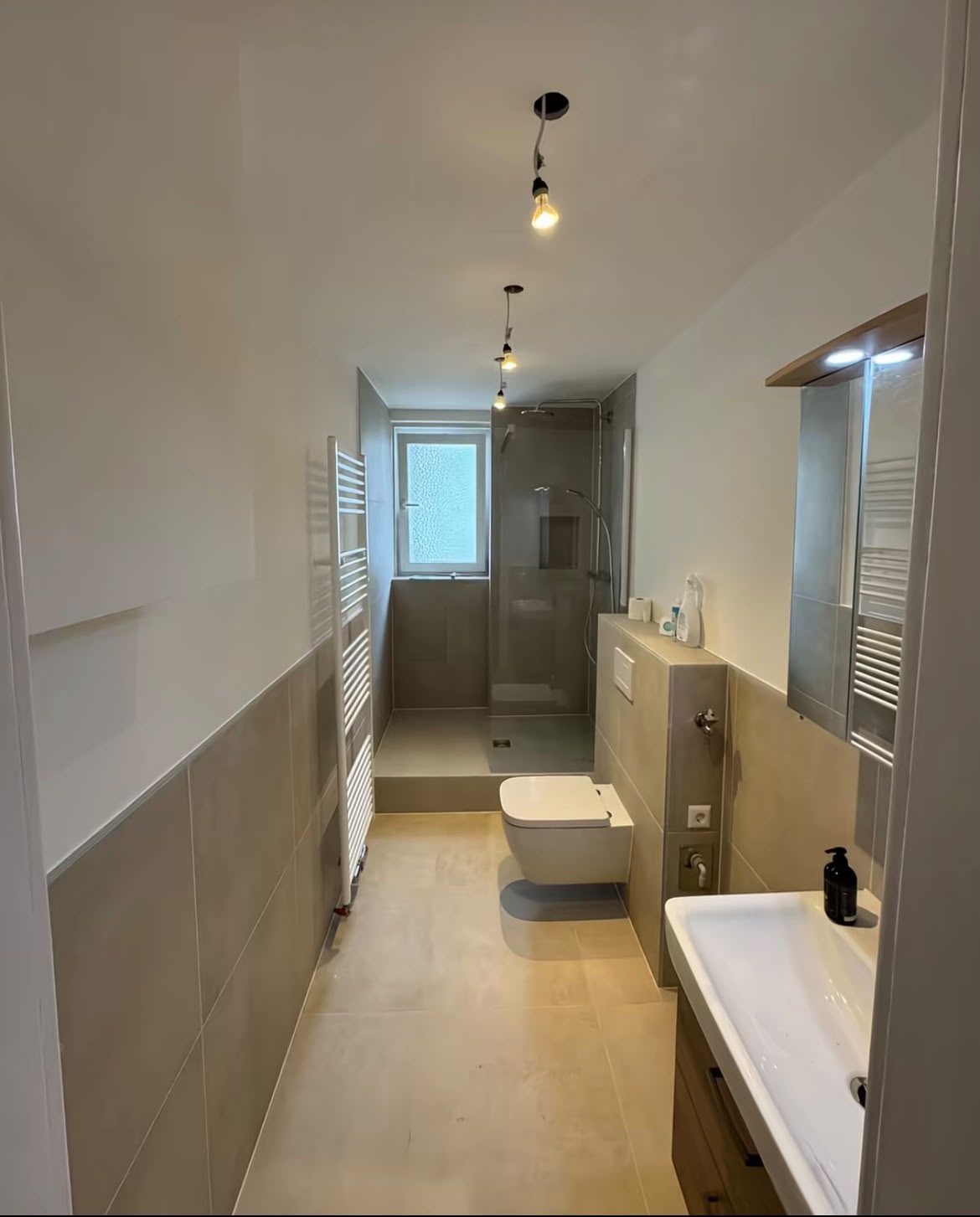 Moderne Badsanierung komplett Schmales Bad mit beigen Fliesen, Walk-in-Dusche und Hänge-WC in Ihrer Region